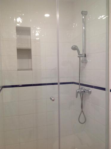 uma casa de banho com um chuveiro e uma porta de vidro em Vehí em Cadaqués