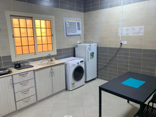 a kitchen with a washing machine and a sink at Economic Homes Apartments in Yanbu