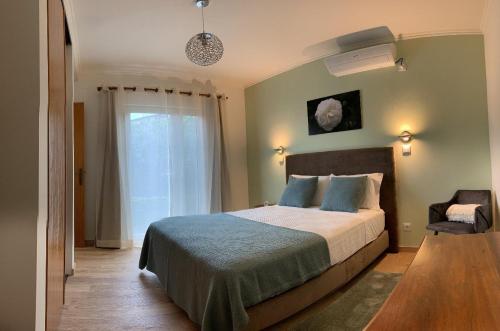 a bedroom with a large bed and a window at Cantinho da Luz in Ponta Delgada