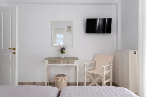 a bedroom with a bed and a desk and a tv at Anna-Marie 1 in Parikia