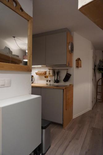 une petite cuisine avec un comptoir blanc et des placards en bois dans l'établissement Le Necou - Reberty 2000, aux Menuires