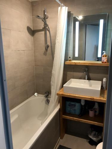 une salle de bain avec une baignoire blanche et un lavabo dans l'établissement Le Necou - Reberty 2000, aux Menuires