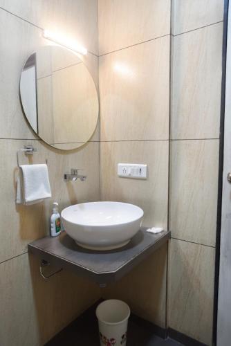 a bathroom with a sink and a mirror at ATITHI INN in Boisar