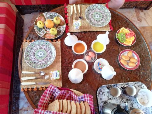 a table with plates of food and cups of coffee at Pearl Surf Camp Morocco in Agadir