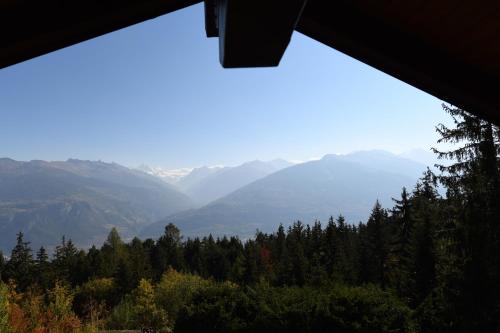 a view of a mountain range from a window at Chalet Mon Rêve in Savièse