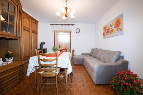 a living room with a table and a couch at Vacation home, Ferienhaus KLAUDIA in Kraj, Mošćenička Draga near Opatija in Mošćenička Draga