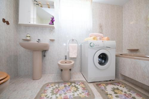 a bathroom with a washing machine and a toilet at Vacation home, Ferienhaus KLAUDIA in Kraj, Mošćenička Draga near Opatija in Mošćenička Draga