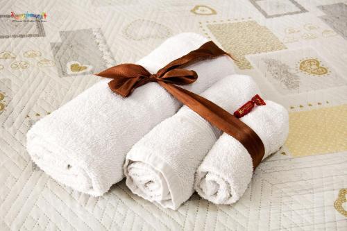 una pila di asciugamani con un fiocco marrone su un letto di b&b l'olimpo a Campobasso