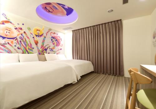 a hotel room with a white bed and a painting at Whoops Hotel in Taichung