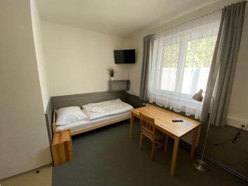 a bedroom with a bed and a table and a desk at Apartmány Přemyslova in Hradec Králové