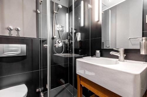 La salle de bains est pourvue d'un lavabo, de toilettes et d'une douche. dans l'établissement YoHo - The Young Hotel, à Hambourg