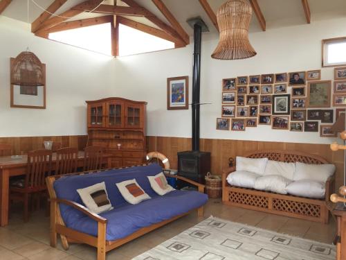 a living room with a blue couch and a stove at Gran casa en Isla Negra in Isla Negra