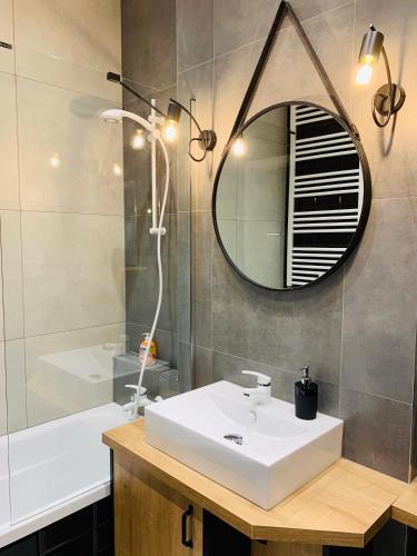 a bathroom with a sink and a mirror and a tub at Property Apart - Soft Lofty Legnicka Centrum in Wrocław