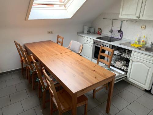 une cuisine avec une table et des chaises en bois dans l'établissement Apartment First Floor Laatzen, à Hanovre