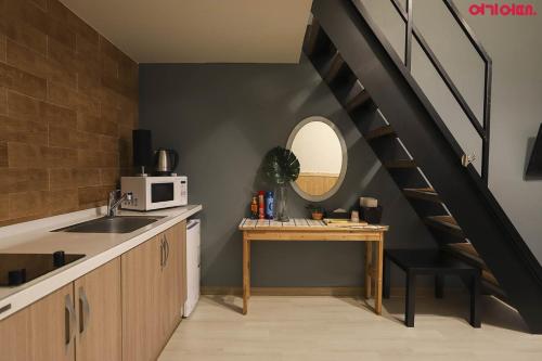 a kitchen with a sink and a spiral staircase at Hotel Hue Loft in Incheon