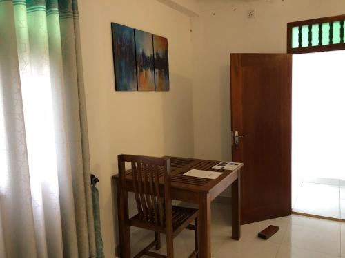 a room with a table and a chair and a door at The Retreat Hotel in Hikkaduwa