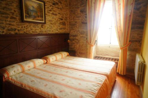 a bedroom with a bed in front of a window at Mirador Da Ribeira in Viana do Bolo