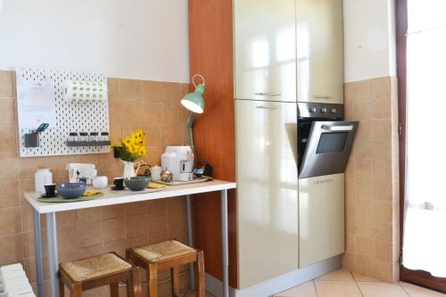 a kitchen with a refrigerator and a counter with stools at Il Nespolo in Cavriglia
