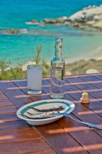 a table with a plate and a glass of water at Ydreos Studios & Apartments in Mikri Vigla