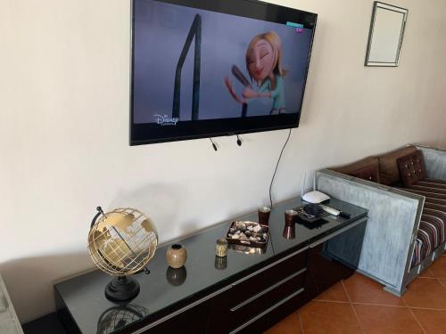 a living room with a tv on the wall at Duplexe Marina Beach in Restinga Smir