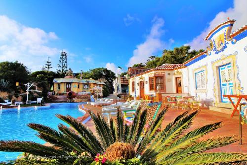 a resort with a swimming pool and a building at Villa Ana Margarida Beach in Ericeira