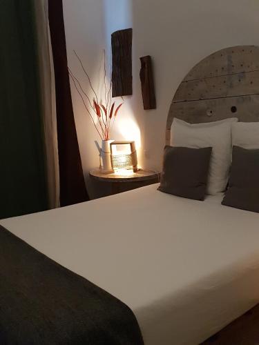 a bedroom with a white bed with a wooden headboard at Cactus Host in Las Palmas de Gran Canaria