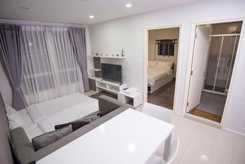 チェンマイにあるD'vieng Santithum Condo by Pingの白いリビングルーム(ソファ、鏡付)