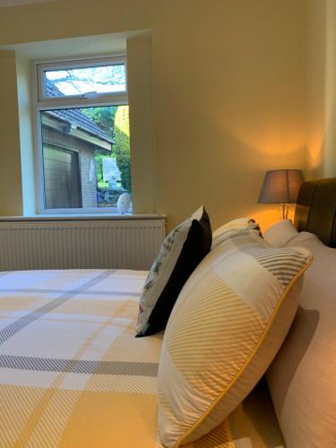 a bedroom with a bed with pillows and a window at The Firs - Moorside Annexe in Douglas