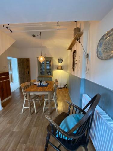 een eetkamer met een tafel en stoelen bij The Stopping Point- Exceptional Cumbrian Cottage in Flookburgh