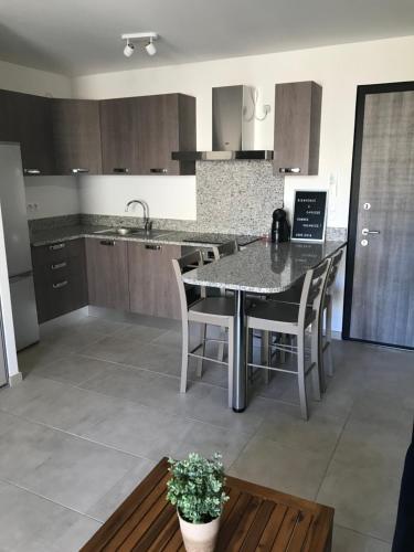 une cuisine avec une table et des chaises dans une pièce dans l'établissement clos des oliviers, à Cargèse