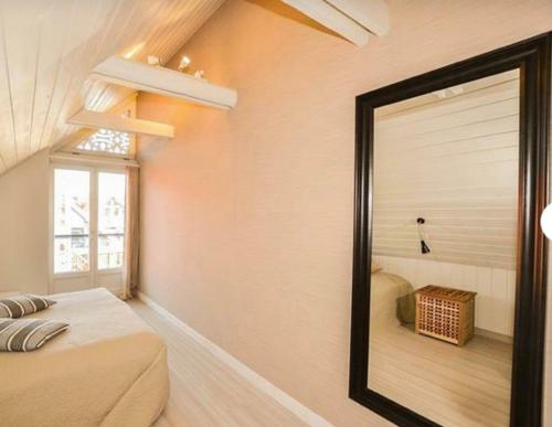 a mirror in a room with a bed and a window at Marių pelėdos in Preila