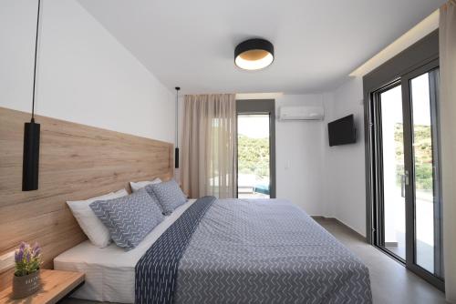 una camera da letto con un grande letto con cuscini blu di Adrianna Villa 1 a Balíon