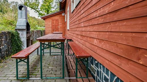 a wooden bench sitting on the side of a building at Apartmány Pod Čerťákem in Dolní Moravice
