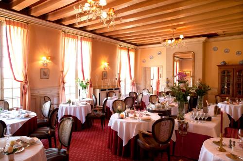 d'une salle à manger avec des tables et des chaises avec des tables blanches. dans l'établissement Château de Beaulieu et Magnolia Spa, The Originals Relais (Relais du Silence), à Joué-lès-Tours