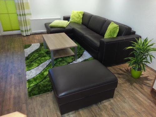 a living room with a black couch and a table at 4 Jahreszeiten in Tamsweg