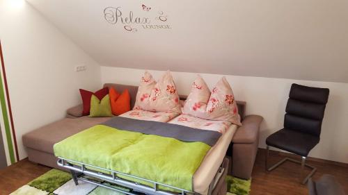 a bedroom with a bed with colorful pillows and a chair at 4 Jahreszeiten in Tamsweg