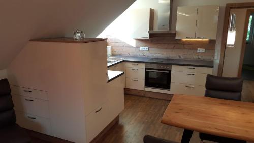 a kitchen with white cabinets and a wooden table at 4 Jahreszeiten in Tamsweg