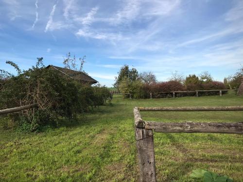 a wooden fence in a field with a house at LE CHARME D OGNES in Ognes