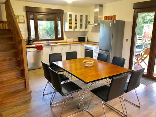 a kitchen with a wooden table and black chairs at Laurel de Gulpiyuri de Llanes in Villahormes