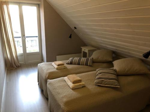 a bedroom with two beds with towels on them at Marių pelėdos in Preila