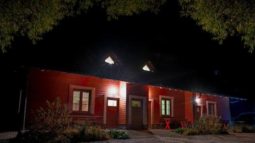 a red brick house with lights on it at night at Apartmány Pod Čerťákem in Dolní Moravice