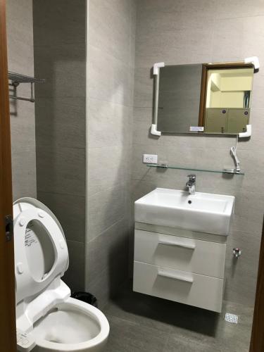 bagno con servizi igienici, lavandino e specchio di Sam-Lin Hostel a Yujing