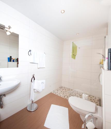 a white bathroom with a sink and a toilet at Ferienwohnung Wohlfühlen in Pfunds