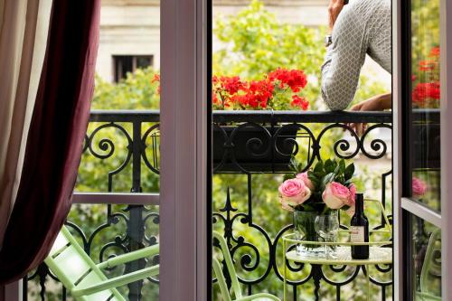 a balcony with a table with flowers on it at Hotel Britannique in Paris
