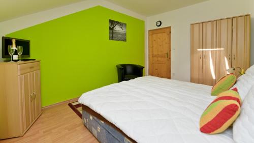 a green bedroom with a bed and a green wall at Wellness Penzion Eva in Dolní Moravice