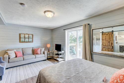 a bedroom with a bed and a couch and a window at Cottages at Fair Haven Cove in Cape Fair