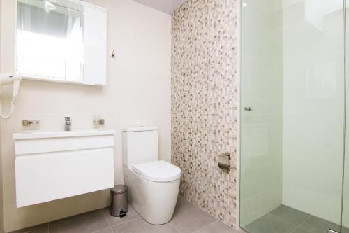 a bathroom with a toilet and a sink and a shower at Victoria Inn Tbilisi in Tbilisi City