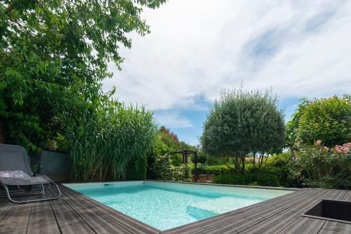 - une piscine avec une terrasse et une chaise à côté dans l'établissement Hibiscus House, à Carcassonne