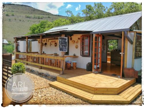 a small house with a porch and a deck at Treur River Lodge in Moremela