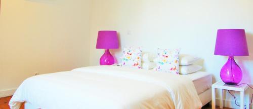 a bedroom with two purple lamps on two beds at Feeling Chiado 15 in Lisbon